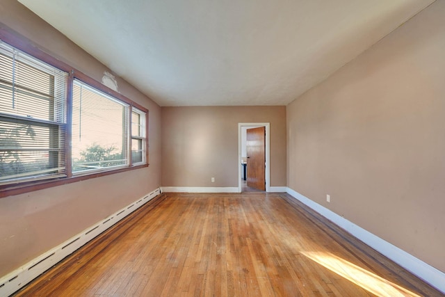 unfurnished room featuring light wood-type flooring and baseboard heating