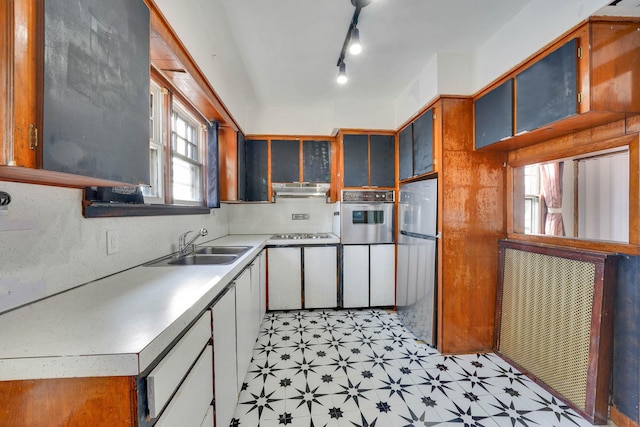 kitchen featuring sink, refrigerator, gas stovetop, track lighting, and oven