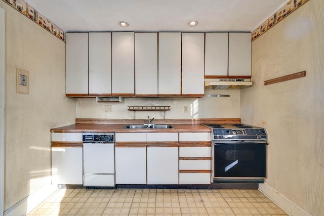 kitchen with electric range oven, sink, and white cabinets