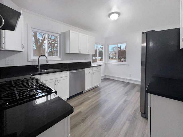 kitchen featuring plenty of natural light, stainless steel appliances, light hardwood / wood-style floors, and white cabinets