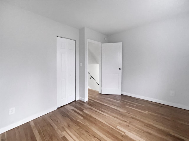 unfurnished bedroom featuring hardwood / wood-style floors and a closet