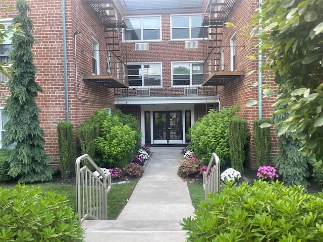 view of exterior entry featuring french doors and brick siding