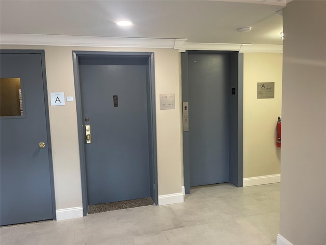 interior space with elevator, crown molding, and baseboards