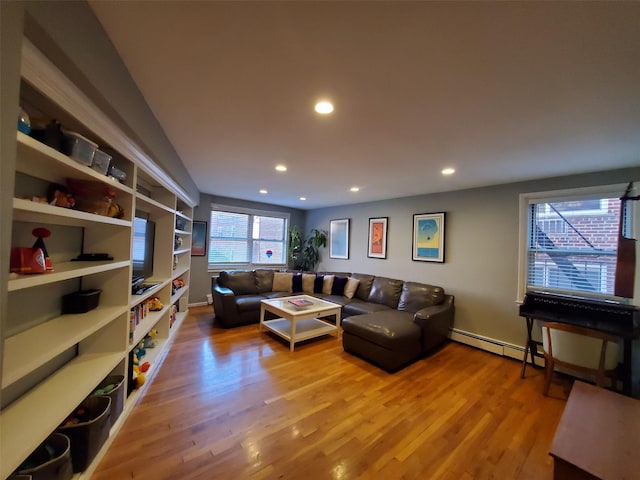 living area featuring a baseboard heating unit, wood finished floors, and recessed lighting