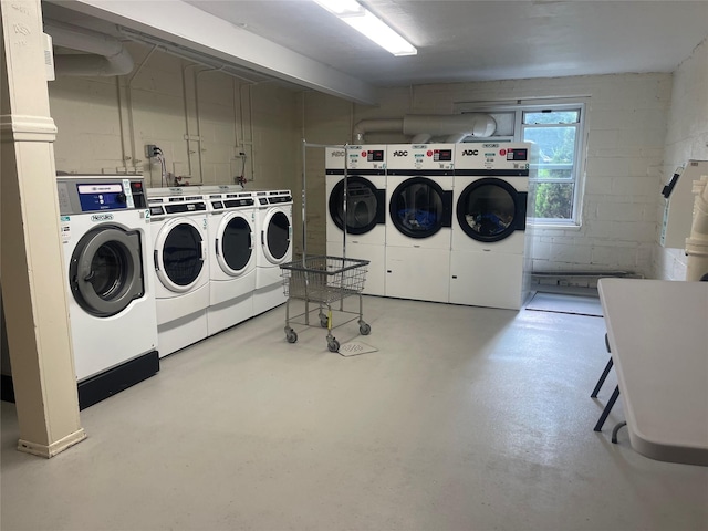 shared laundry area featuring washing machine and dryer and concrete block wall