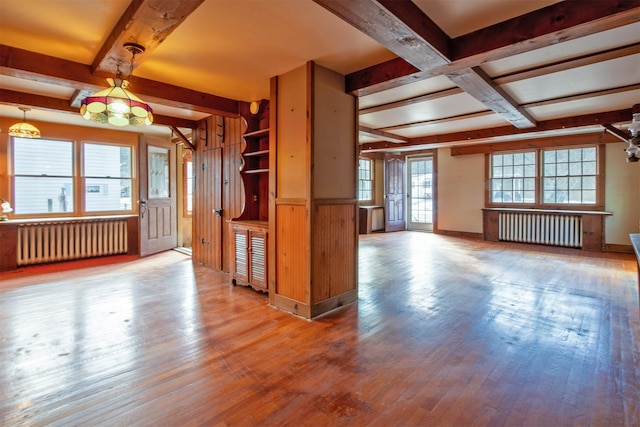 interior space with beamed ceiling, radiator heating unit, and wood-type flooring