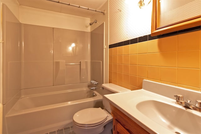 full bathroom featuring bathing tub / shower combination, tile walls, vanity, and toilet