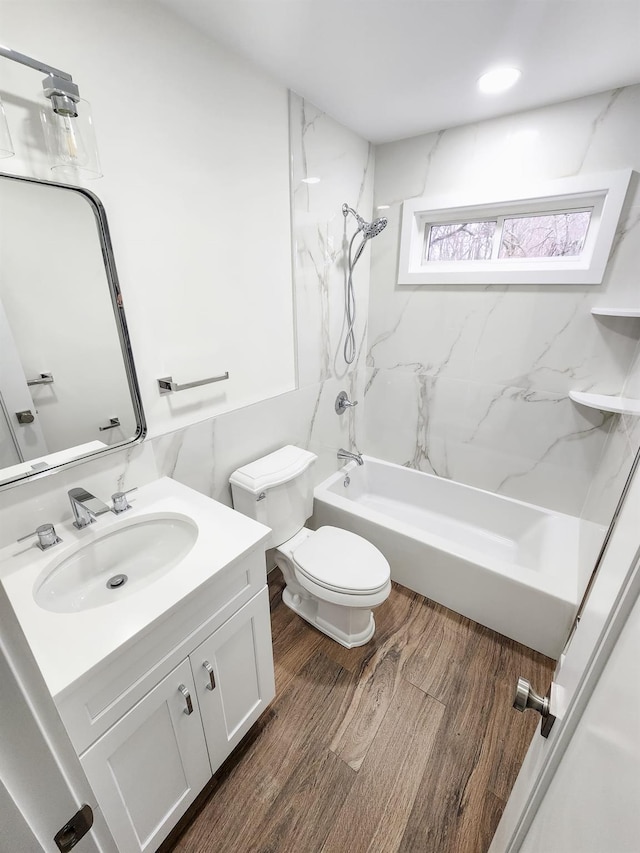 full bathroom with tiled shower / bath, vanity, toilet, and wood-type flooring