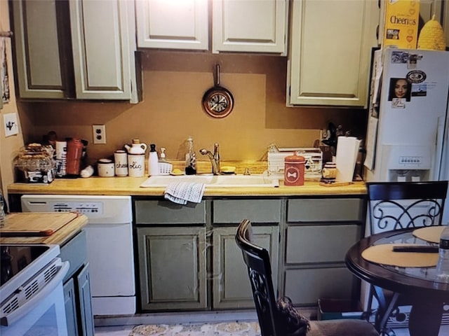 kitchen featuring butcher block counters, sink, white appliances, and gray cabinets