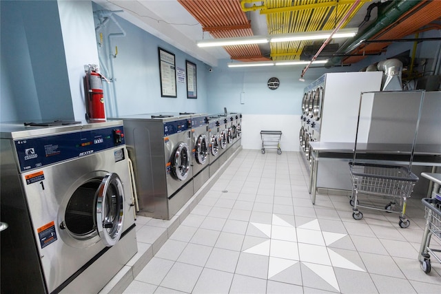 laundry area with light tile patterned floors and washing machine and dryer