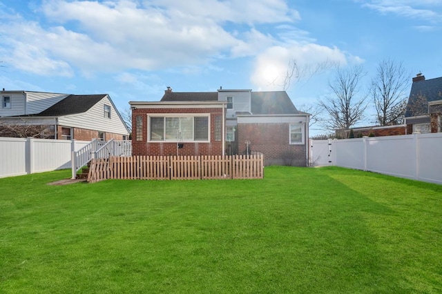 rear view of house with a wooden deck and a yard