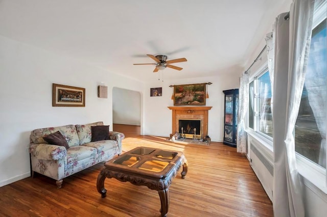 living room featuring radiator heating unit, wood-type flooring, and ceiling fan