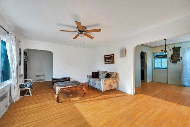 living area with hardwood / wood-style flooring, ceiling fan, and radiator