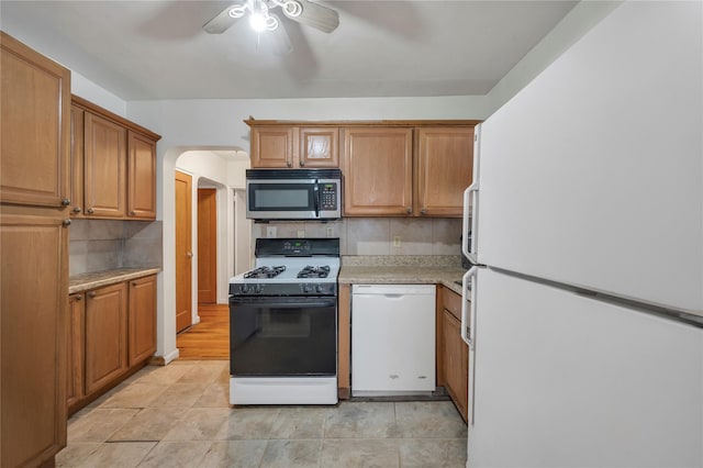 kitchen featuring ceiling fan, white appliances, light tile patterned floors, and backsplash