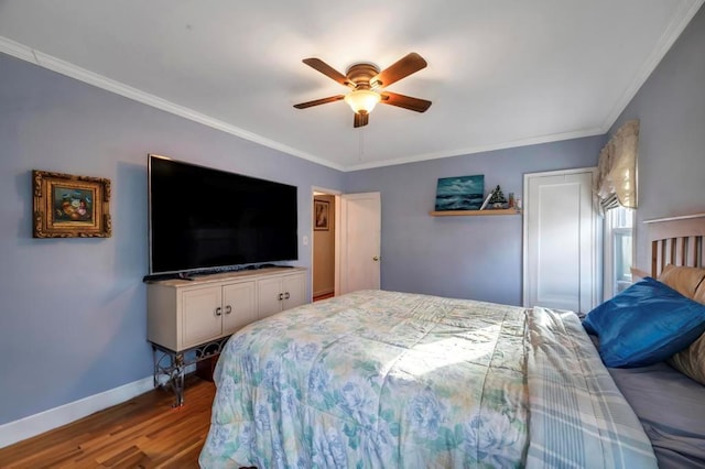 bedroom featuring hardwood / wood-style flooring, ornamental molding, and ceiling fan