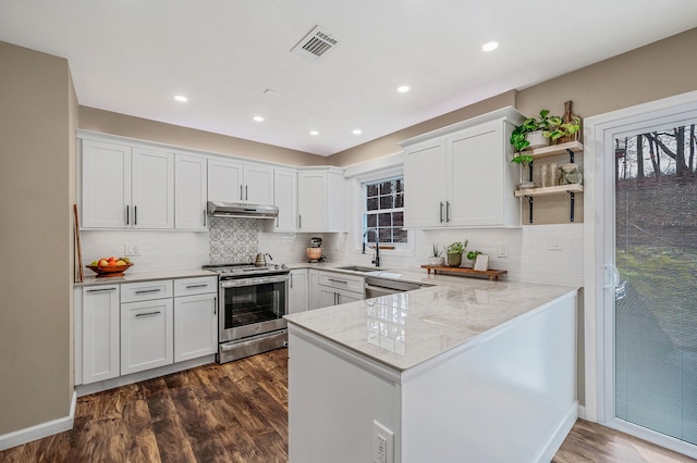 kitchen with sink, stainless steel appliances, kitchen peninsula, and white cabinets