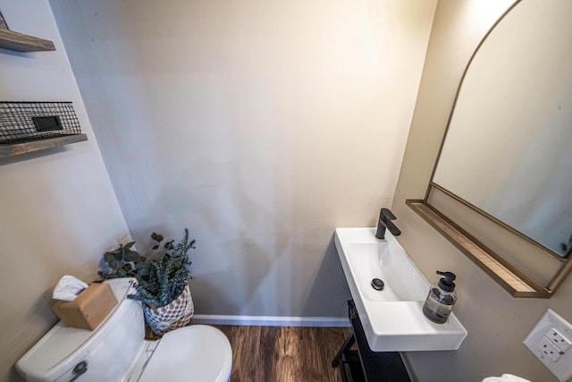 bathroom with hardwood / wood-style flooring and toilet