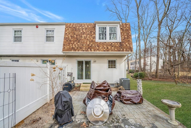 rear view of house with central AC unit, a patio area, and a lawn