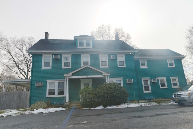 view of front of home featuring a wall mounted air conditioner and a porch