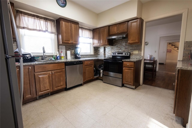 kitchen featuring sink, decorative backsplash, stainless steel appliances, and stone counters