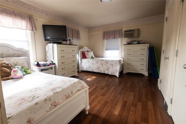 bedroom featuring dark hardwood / wood-style flooring and an AC wall unit