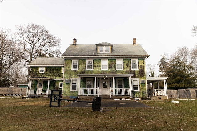 back of property with a porch and a yard