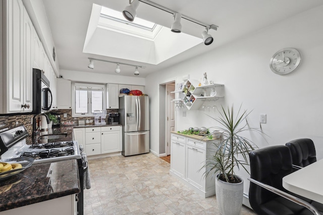 kitchen featuring white cabinets, a skylight, and black appliances