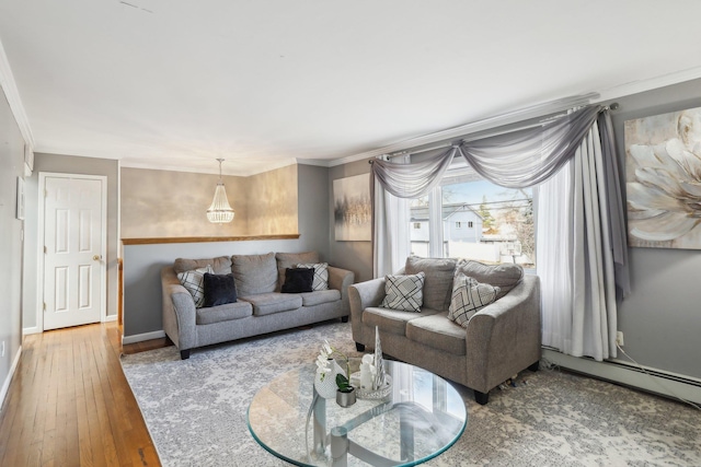 living room with hardwood / wood-style floors, crown molding, and a baseboard heating unit