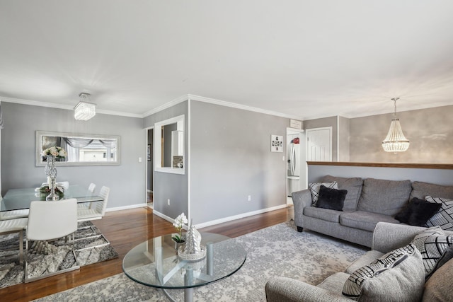 living room featuring a notable chandelier, crown molding, and wood-type flooring