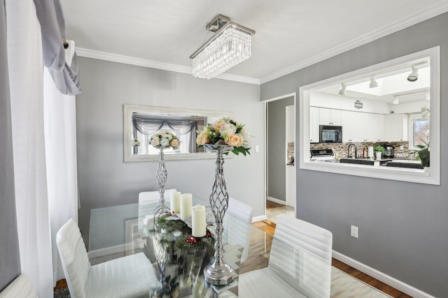 dining area with an inviting chandelier and ornamental molding