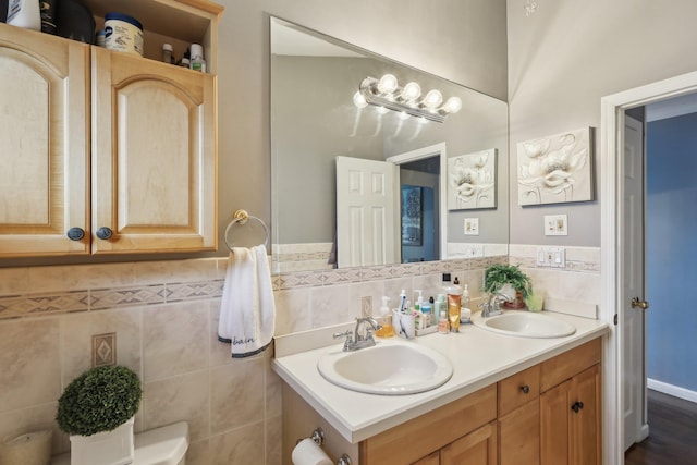 bathroom featuring vanity, toilet, and tile walls