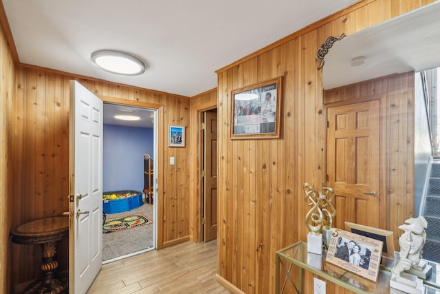 corridor featuring wooden walls and light hardwood / wood-style flooring