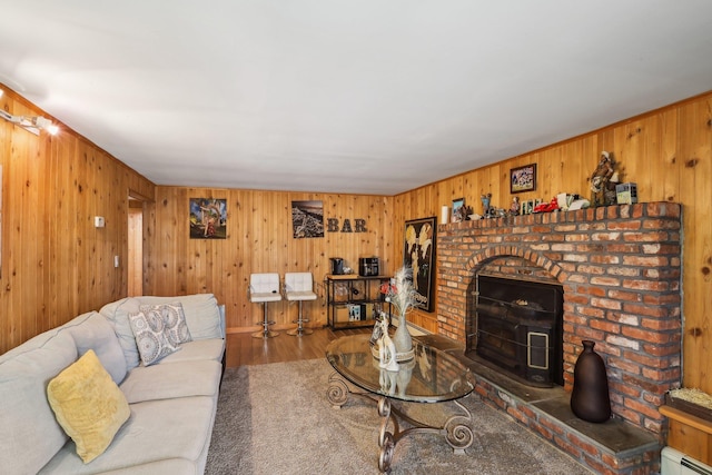 living room featuring a baseboard radiator, wood-type flooring, and wood walls