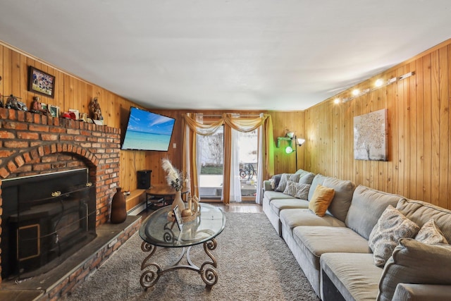 living room with wood-type flooring, a brick fireplace, and wooden walls