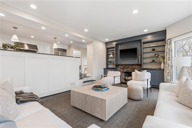 living area with built in features, recessed lighting, visible vents, a brick fireplace, and stairs