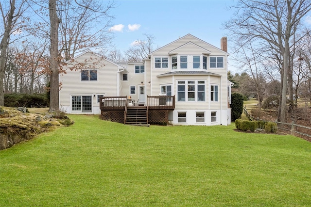 rear view of house with a chimney, a yard, and a deck