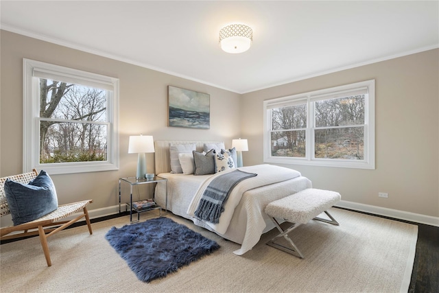 bedroom featuring baseboards, crown molding, and wood finished floors