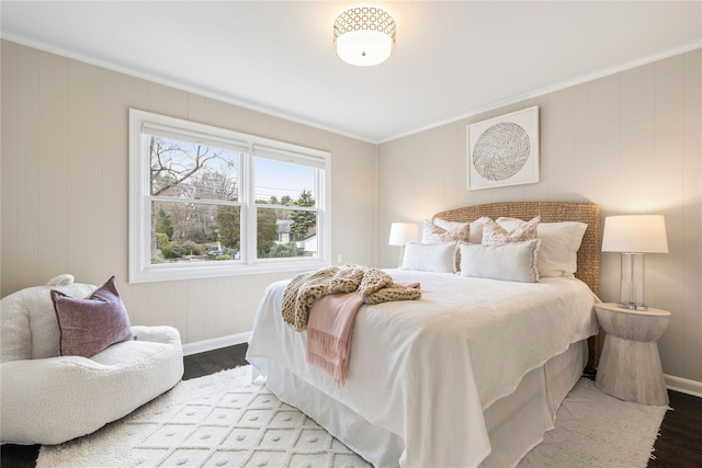 bedroom featuring crown molding, wood finished floors, and baseboards