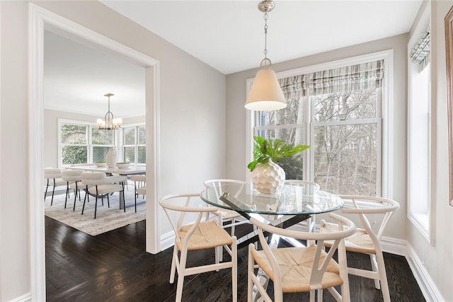 dining room featuring baseboards, dark wood finished floors, and a notable chandelier