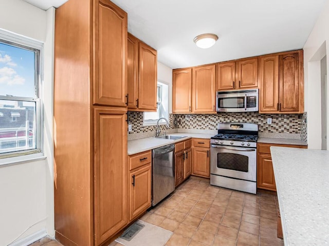 kitchen featuring stainless steel appliances, tasteful backsplash, sink, and light tile patterned floors