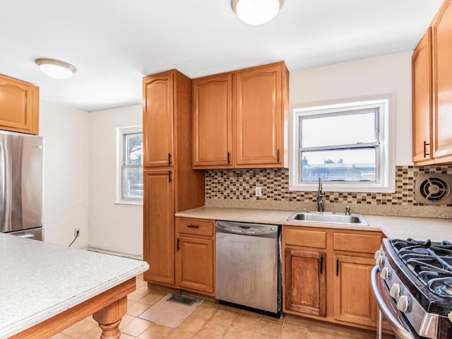 kitchen featuring appliances with stainless steel finishes, sink, plenty of natural light, and decorative backsplash