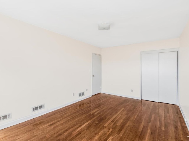 unfurnished bedroom with hardwood / wood-style flooring and a closet