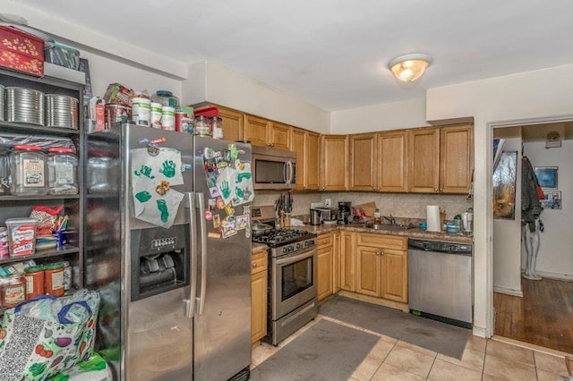 kitchen featuring light tile patterned floors, stainless steel appliances, and sink