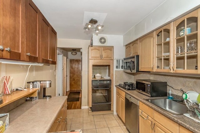 kitchen featuring backsplash, light tile patterned floors, stainless steel appliances, and sink