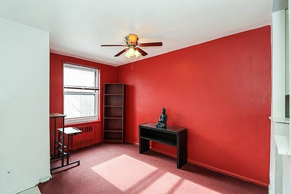 misc room with radiator, ceiling fan, and carpet