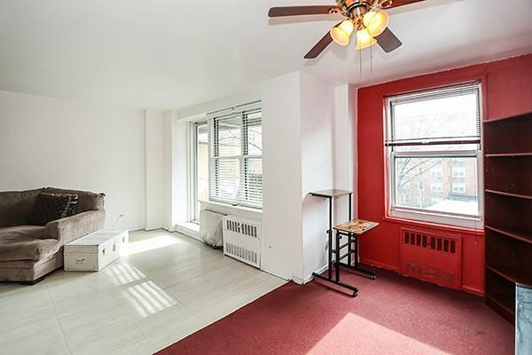 living room with ceiling fan and radiator