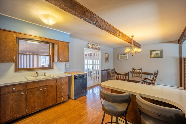 kitchen with pendant lighting, beamed ceiling, dishwasher, sink, and light hardwood / wood-style flooring