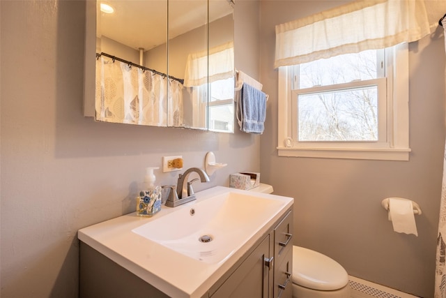 bathroom with vanity, a wealth of natural light, toilet, and baseboard heating