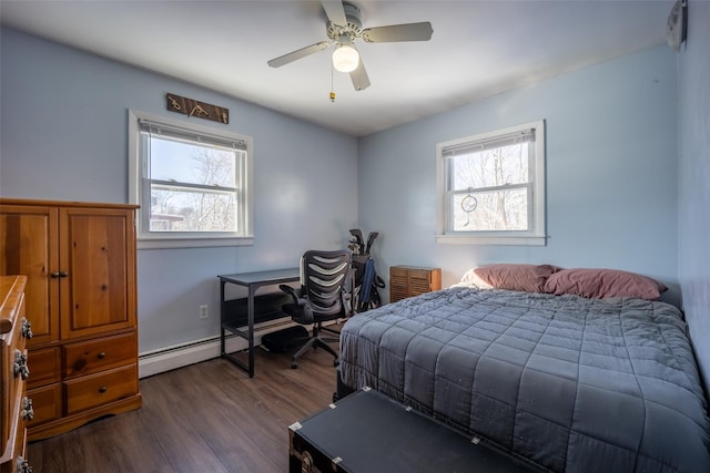 bedroom with multiple windows, dark wood-type flooring, ceiling fan, and baseboard heating