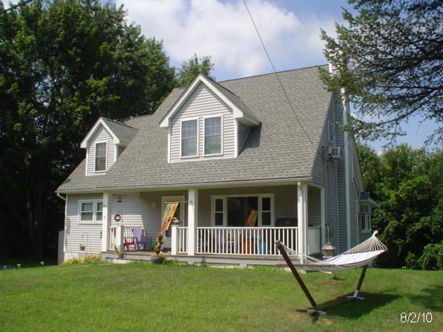 cape cod-style house with a porch and a front yard